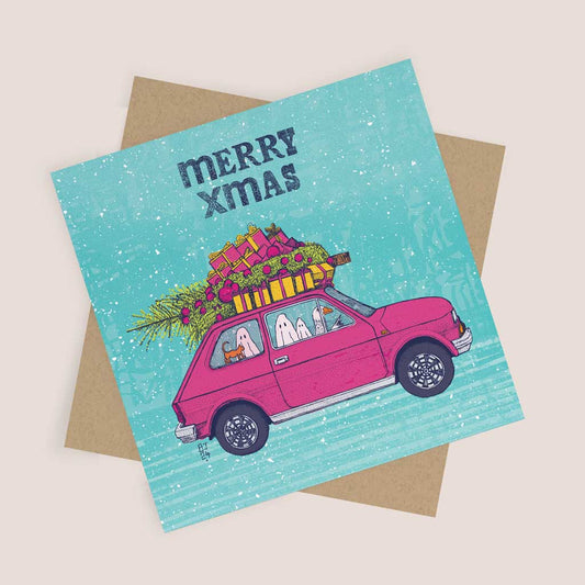 Illustration of a pink car piled high with Christmas gifts and a tree, driven by ghosts with a goose and a cat inside, accompanied by the text “Merry Xmas” on a snowy background.